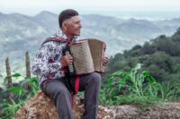 Músico tocando vallenato en el campo colombiano.